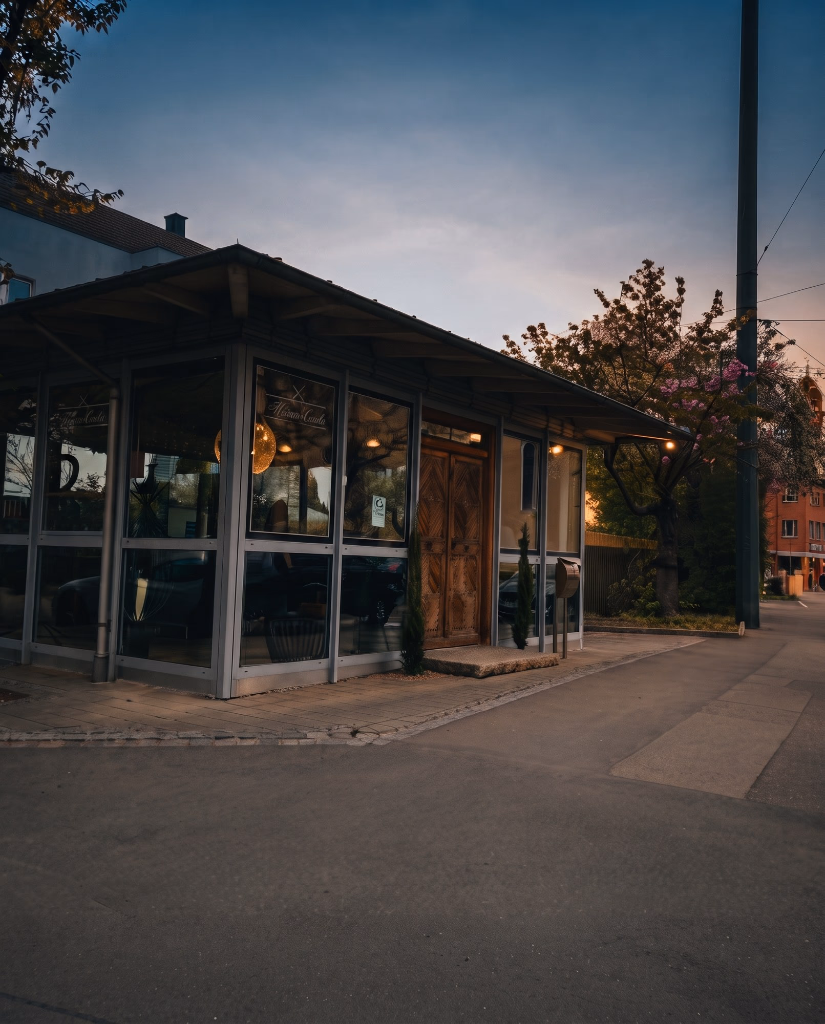 Der Glaspavillon von Haar Exakt an der Stadtberger Straße in Augsburg-Pfersee, abends
